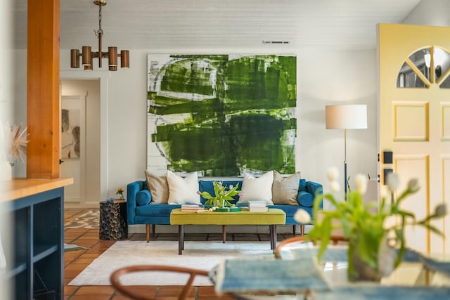 living area featuring tile patterned flooring, visible vents, and a chandelier