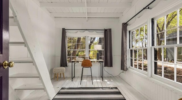 sunroom / solarium featuring wooden ceiling, beamed ceiling, and a wealth of natural light