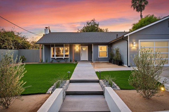 view of front of property with a front lawn, a porch, fence, and roof with shingles