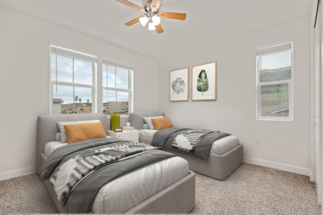 bedroom with baseboards, multiple windows, and a ceiling fan