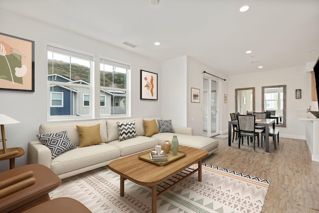 living area featuring visible vents, recessed lighting, baseboards, and wood finished floors