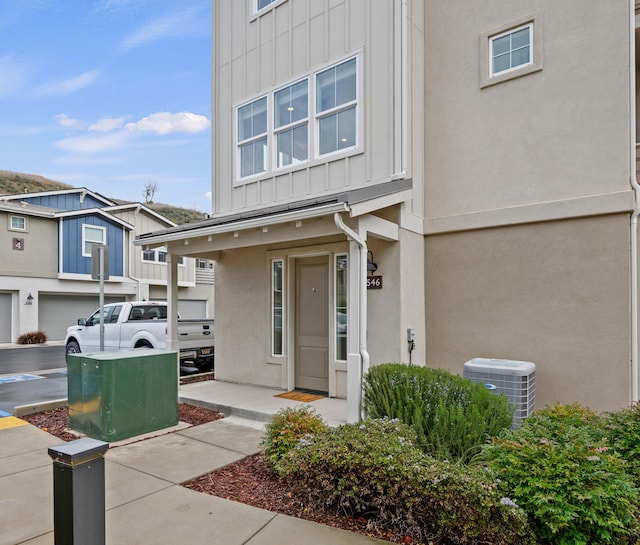 view of front of property with central air condition unit, board and batten siding, and stucco siding