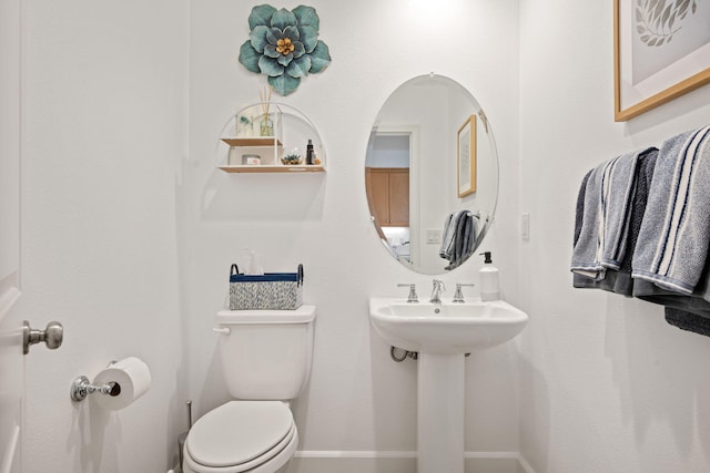 bathroom with baseboards and toilet