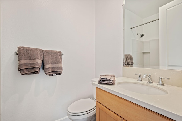 bathroom featuring vanity, toilet, and a shower