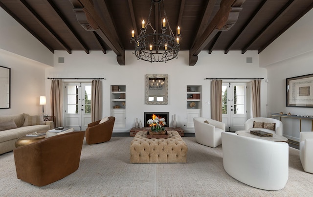 living room featuring beamed ceiling, a healthy amount of sunlight, and a lit fireplace