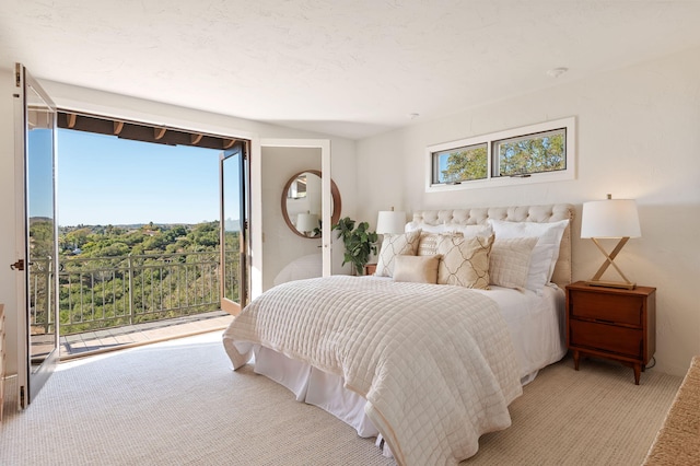 bedroom with access to outside and light carpet