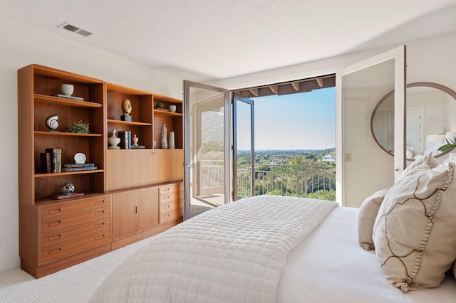 bedroom with visible vents, carpet, and access to outside