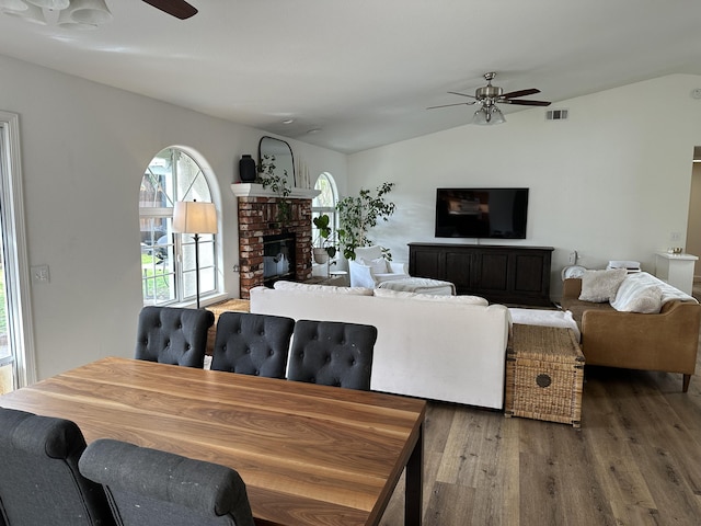 living area with vaulted ceiling, wood finished floors, visible vents, and ceiling fan