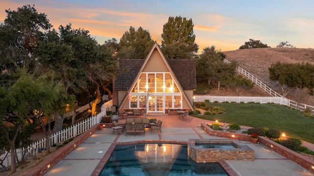 view of swimming pool with an outbuilding, a patio, a yard, a fenced backyard, and a storage structure