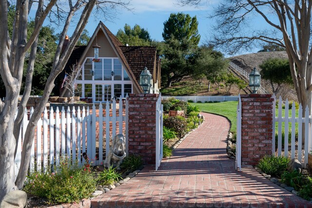 view of gate with a lawn and fence