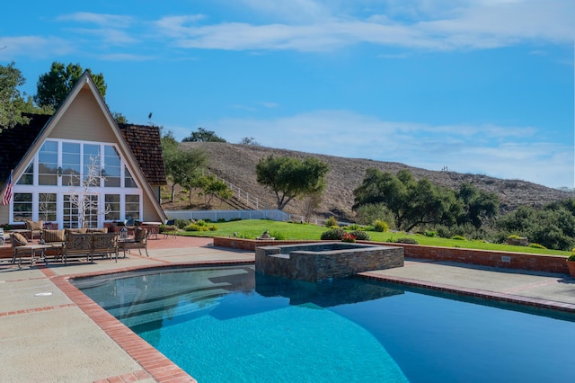 view of pool featuring a patio and a pool with connected hot tub