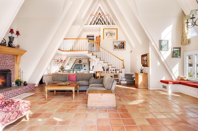 living area with stairs, a high ceiling, light tile patterned floors, and a fireplace