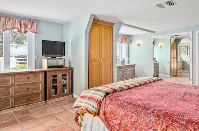 bedroom featuring visible vents, baseboards, and light tile patterned flooring