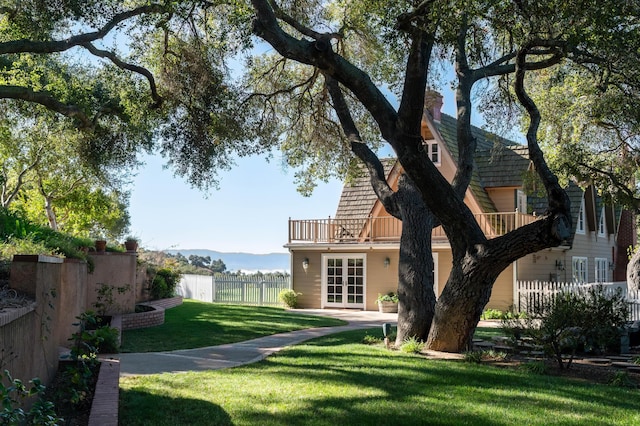 view of yard featuring french doors and fence