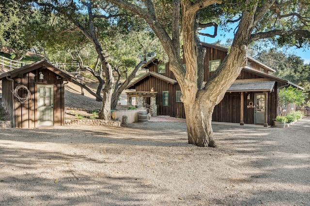 view of front of house with an outbuilding, board and batten siding, and a storage shed