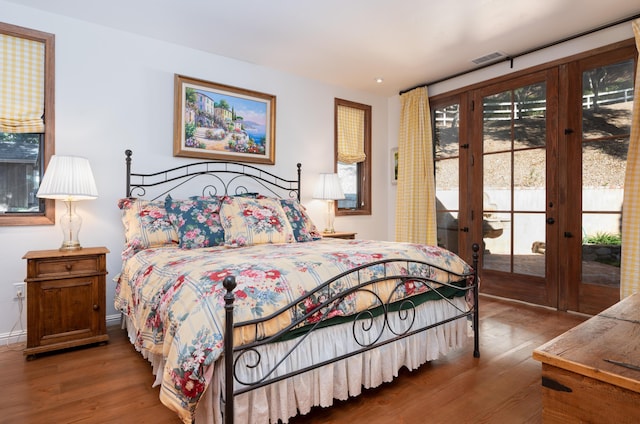 bedroom featuring french doors, visible vents, wood finished floors, and access to outside