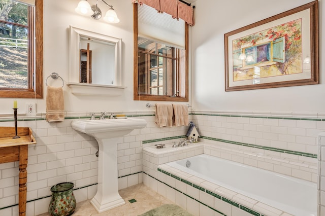 bathroom featuring tile walls, a bath, tile patterned floors, and wainscoting