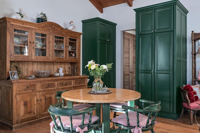 dining room with beam ceiling and light wood-type flooring