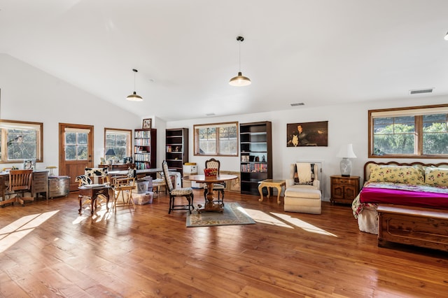 living area featuring visible vents, wood-type flooring, and high vaulted ceiling