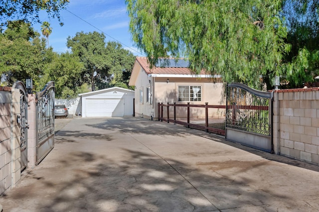 view of side of home featuring an outbuilding, a gate, fence, and metal roof