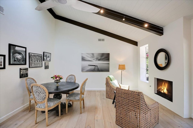 5134 Cathedral Oaks Rd, Santa Barbara, CA 93111 - dining room with light wood finished floors, visible vents, vaulted ceiling with beams, and a lit fireplace