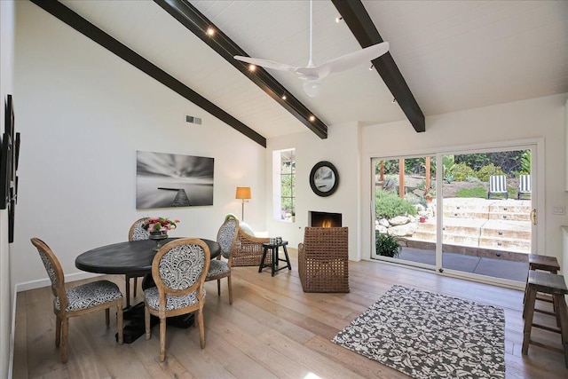 5134 Cathedral Oaks Rd, Santa Barbara, CA 93111 - dining area with beamed ceiling, light wood finished floors, a healthy amount of sunlight, and a warm lit fireplace