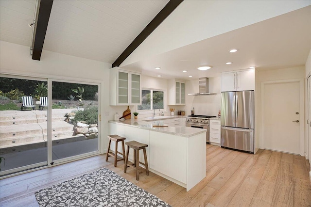 5134 Cathedral Oaks Rd, Santa Barbara, CA 93111 - kitchen with vaulted ceiling with beams, wall chimney range hood, a peninsula, stainless steel appliances, and a sink