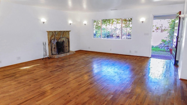 unfurnished living room with wood-type flooring and a fireplace