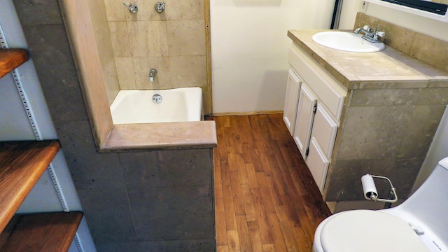 bathroom with toilet, vanity, and wood finished floors