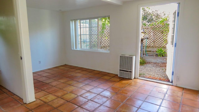 empty room with heating unit and tile patterned floors