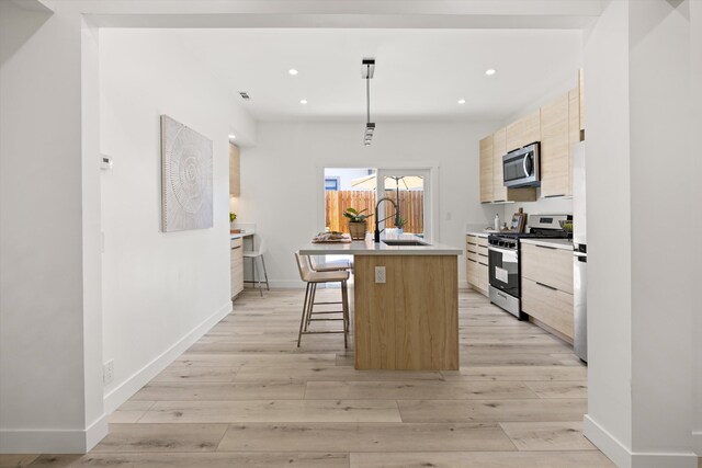 334 W Mission St, Santa Barbara, CA 93101 - kitchen with stainless steel appliances, modern cabinets, light brown cabinetry, a center island with sink, and a sink