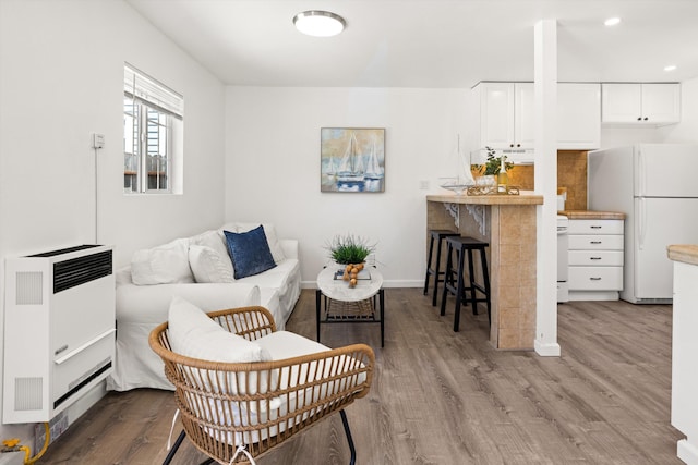 334 W Mission St, Santa Barbara, CA 93101 - living area with heating unit, wood finished floors, baseboards, and recessed lighting