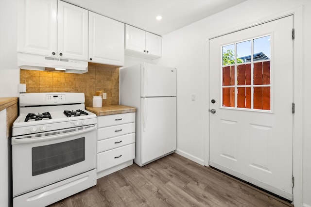 334 W Mission St, Santa Barbara, CA 93101 - kitchen with white appliances, under cabinet range hood, light wood finished floors, white cabinetry, and decorative backsplash