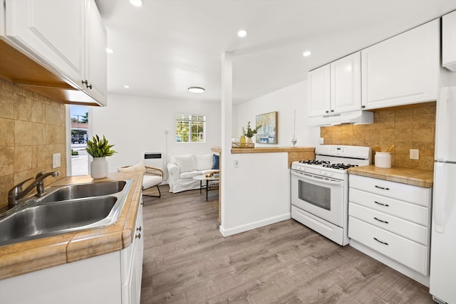 334 W Mission St, Santa Barbara, CA 93101 - kitchen with white appliances, under cabinet range hood, a sink, light wood-type flooring, and white cabinets
