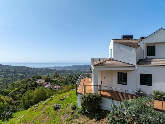 view of side of property featuring stucco siding and a tiled roof