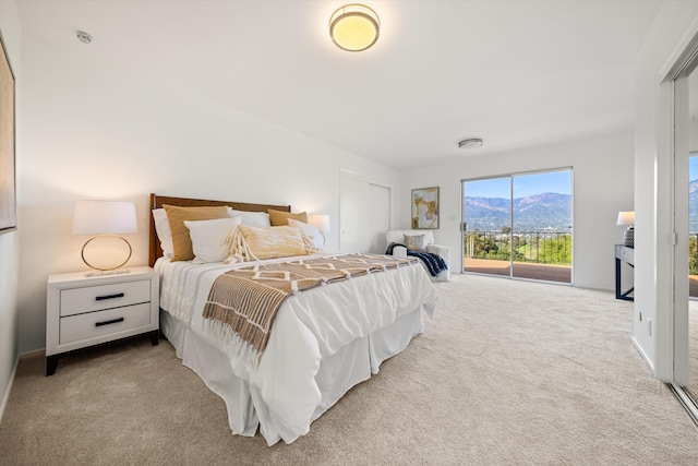 carpeted bedroom with a mountain view and access to outside