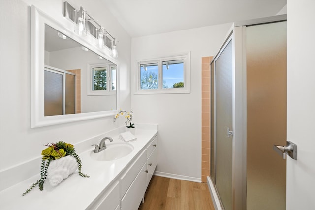 bathroom featuring vanity, wood finished floors, and a stall shower