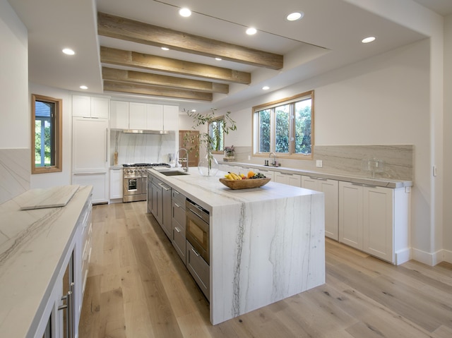 741 Saddle Ln, Ojai, CA 93023 - kitchen featuring appliances with stainless steel finishes, a sink, white cabinets, tasteful backsplash, and light stone countertops