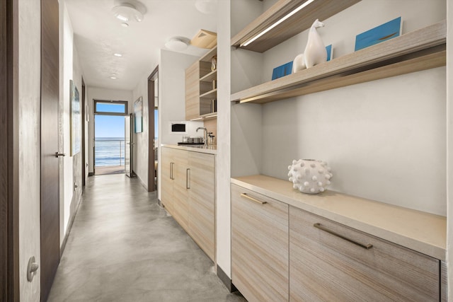 hallway with concrete floors and a sink