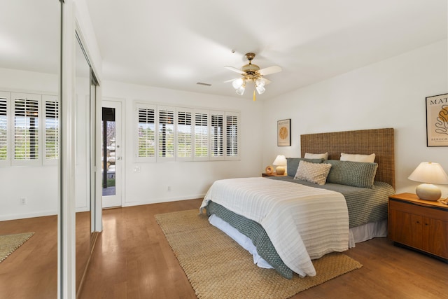 bedroom with visible vents, baseboards, a ceiling fan, and wood finished floors