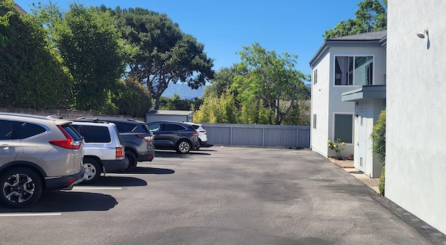 uncovered parking lot featuring fence