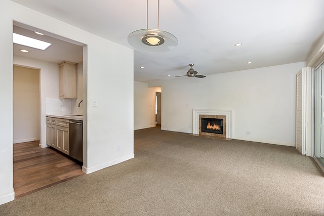 unfurnished living room with recessed lighting, dark colored carpet, and baseboards