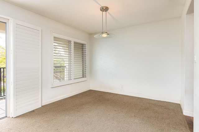 spare room featuring dark carpet and baseboards