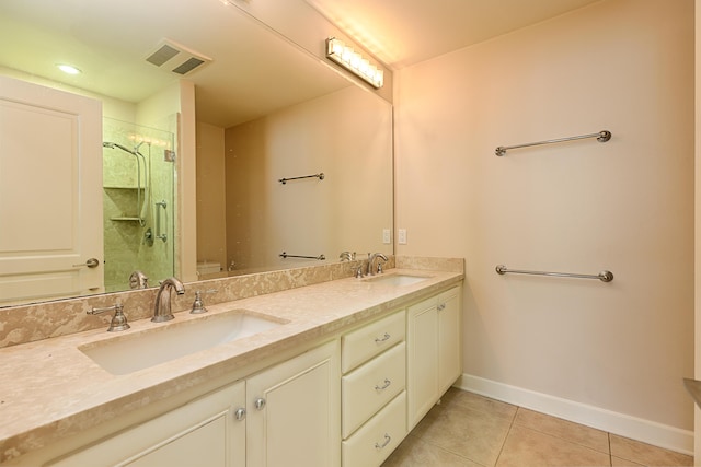 bathroom featuring a sink, a shower stall, visible vents, baseboards, and tile patterned flooring