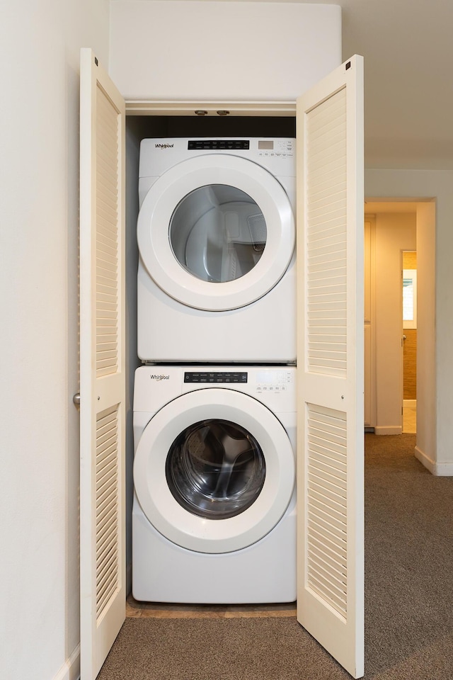 laundry room featuring carpet, stacked washer and clothes dryer, and laundry area
