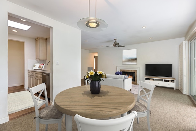 dining room with ceiling fan, recessed lighting, a warm lit fireplace, and baseboards