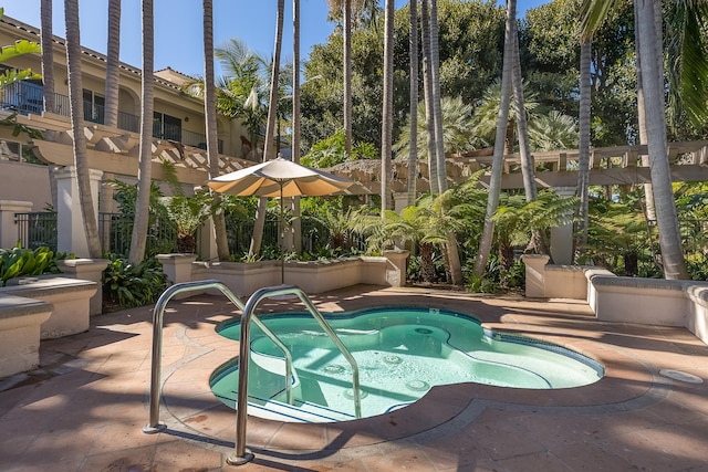 view of swimming pool with a patio area and a hot tub