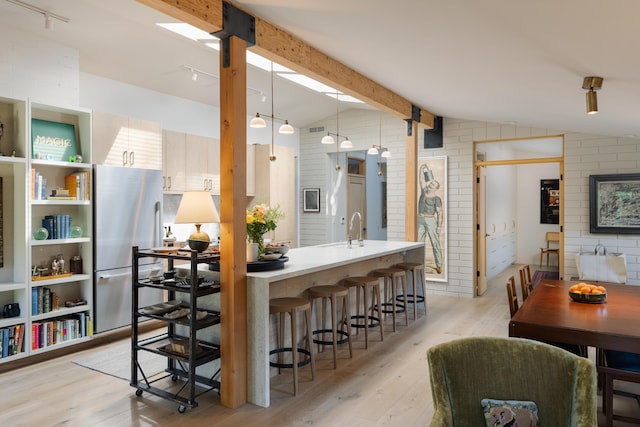 216 E Matilija St, Ojai, CA 93023 - interior space with light wood finished floors, freestanding refrigerator, lofted ceiling with beams, and a kitchen breakfast bar