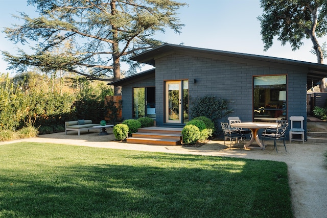 216 E Matilija St, Ojai, CA 93023 - back of house with a patio, brick siding, outdoor lounge area, and a lawn