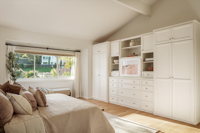 bedroom featuring light wood finished floors and lofted ceiling with beams